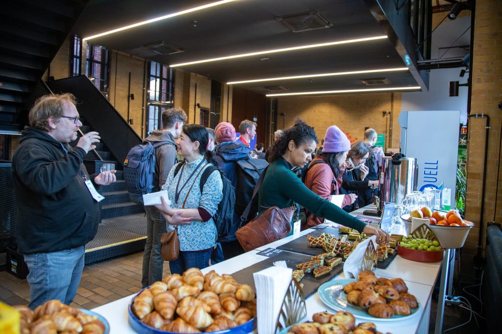 People talking to each other at a breakfast buffet.